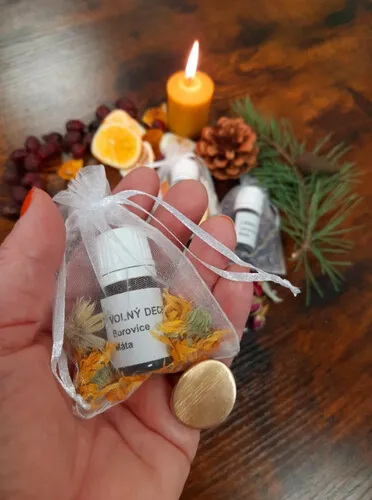 Ruka drží lahvičku přírodního deodorantu s borovicí a mátou v organzovém sáčku