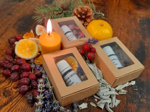 Dárkové krabičky s aroma směsmi a hořící svíčka mezi sušenými pomeranči